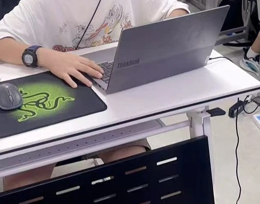 手部操作笔记本电脑键盘的课堂近景